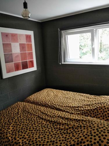a bedroom with a bed with a cheetah print sheets at le dépot 2 appartement 406 in Malmedy