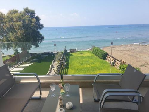 a balcony with a table and chairs and the ocean at Periyiali Beach Sunset Suite A7 in Pervolia