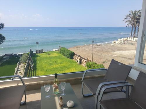 a balcony with a table and chairs and the ocean at Periyiali Beach Sunset Suite A7 in Pervolia