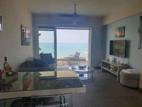 Periyiali Beach Sunset Suite A7 في بريفوليا: غرفة معيشة مطلة على المحيط