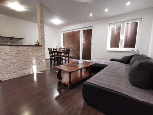 - un salon avec un canapé et une table dans l'établissement Apartment J&D, à Dunajská Streda