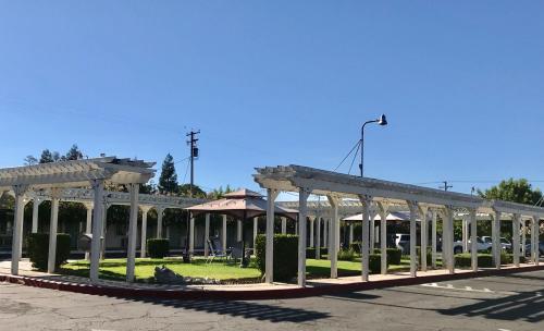 a building with white columns and a pavilion at Sunrise Inn in Turlock