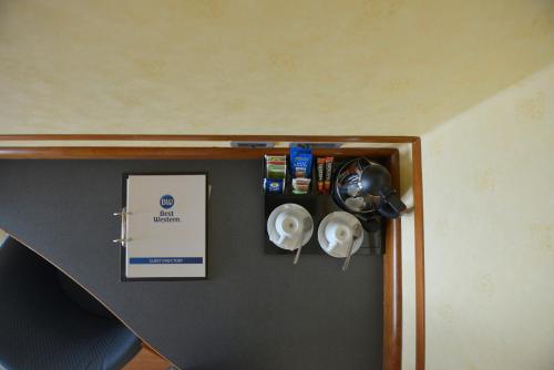 a corner of a room with a shelf with pots and pans at Best Western Hotel I Colli in Macerata