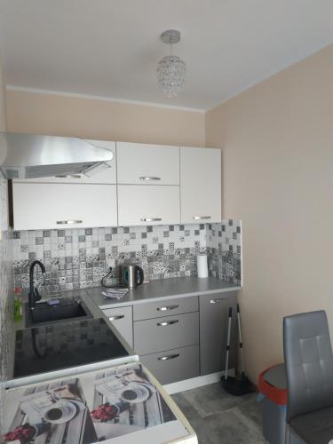 a kitchen with a sink and a stove top oven at Oskar Apartament Centrum PKP in Mińsk Mazowiecki
