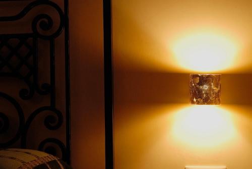 a lamp on a wall next to a bed at Dimora Storica ''Casa Sicuro'' in Martano