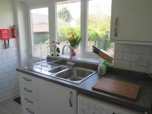 a kitchen counter with a sink and a window at The Bungalow Lymington 1 mile from New Forest in Lymington