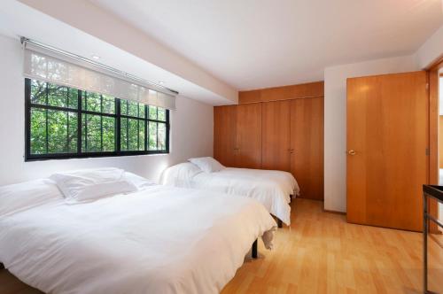 a bedroom with two beds and a window at Lovely apartment Ahuehuetes in Mexico City