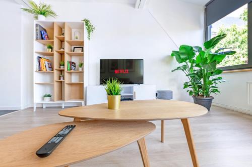 a coffee table in a living room with a remote control at Les Cerisiers - Appartement de Standing au Centre de Namur in Namur