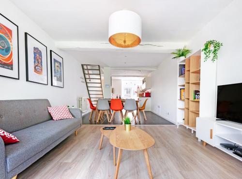 a living room with a couch and a table at Les Cerisiers - Appartement de Standing au Centre de Namur in Namur