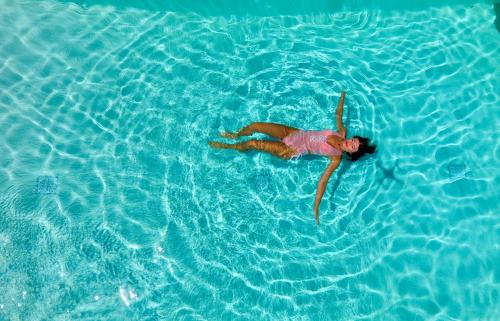 a woman swimming in a pool of water at PIOTROWSKI APARTMENTS in Theológos