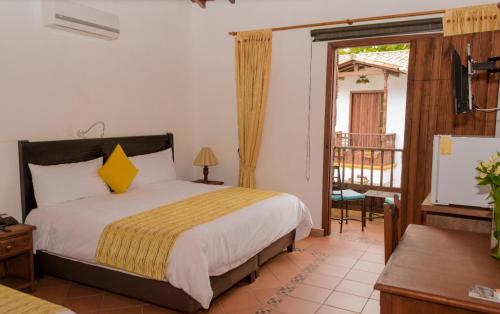 a bedroom with a bed and a balcony at HOTEL Alejandria Barichara in Barichara