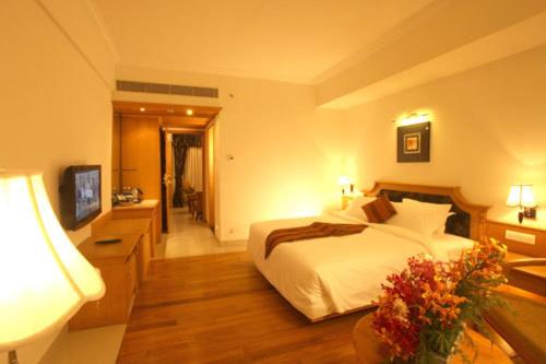 a hotel room with a bed and a bathroom at SP Grand Days in Trivandrum