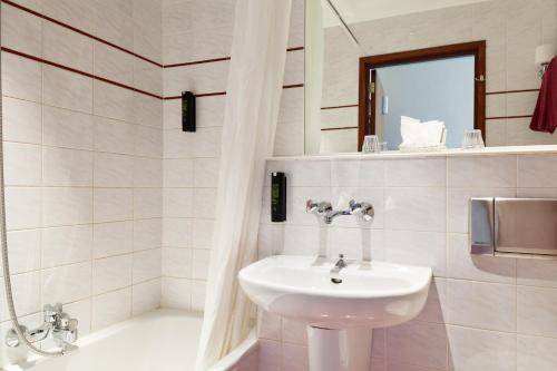 アムステルダムにあるホテル ザ ネイバーズ マグノリアの白いバスルーム(シンク、鏡付)