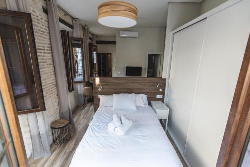 Dormitorio pequeño con cama con sábanas y almohadas blancas en Sol y Luna de Triana, en Sevilla