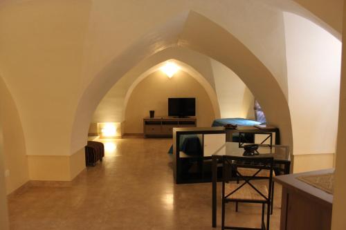 a room with an archway with a desk and a television at Dimora Storica ''Casa Sicuro'' in Martano
