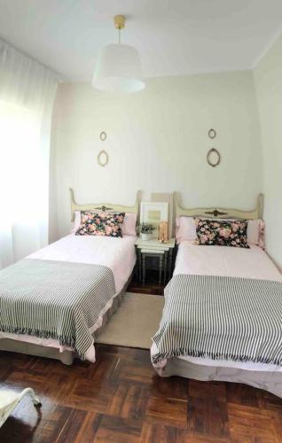 a bedroom with two beds and a table with a mirror at El Rincón de El Montán in Avilés