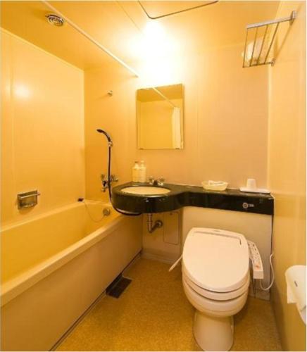 a bathroom with a toilet and a sink and a tub at Highness Hotel Kurume in Kurume