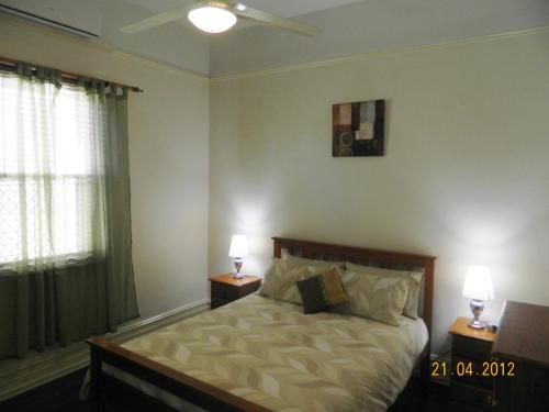 um quarto com uma cama com duas mesas de cabeceira e dois candeeiros em Champion Bay Apartments em Geraldton