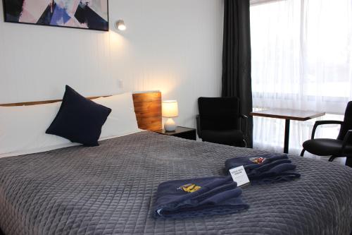 a hotel room with a bed with two towels on it at Glynlea Motel in Horsham