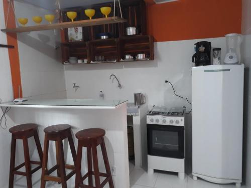 una cucina con bancone, sgabelli e frigorifero di Ita do Mar a Morro de São Paulo