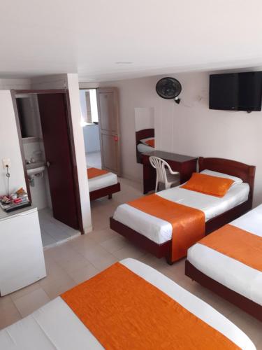 a hotel room with two beds and a desk at Hotel Center in Ibagué