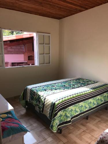 ein Schlafzimmer mit einem Bett in einem Zimmer mit einem Fenster in der Unterkunft Casa Ibitipoca in Conceição da Ibitipoca