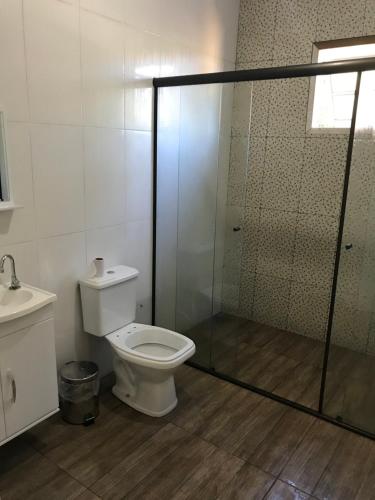 ein Badezimmer mit Toilette und Glasdusche in der Unterkunft Casa Ibitipoca in Conceição da Ibitipoca