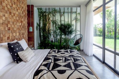 een slaapkamer met een bed en een groot raam bij Villa Nonnavana - 12-minute walk to Batu Bolong Beach in Canggu
