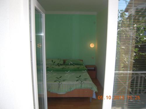 a bedroom with a bed in a room with a window at Lile Pestani Accommodation in Peštani