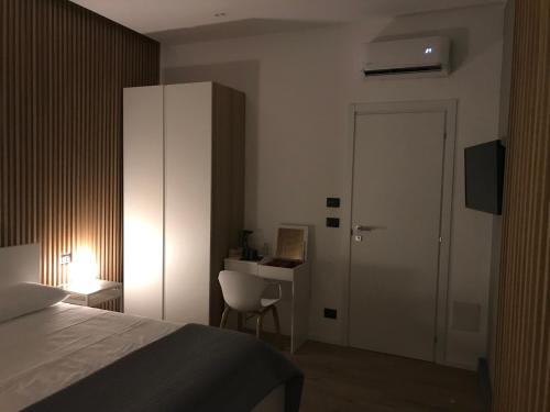 a bedroom with a bed and a desk and a door at Le Dimore Degli Archi Catania in Catania