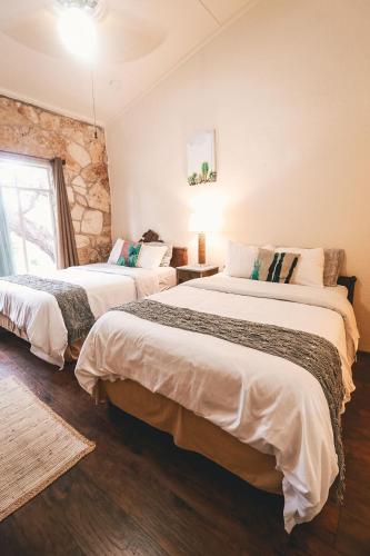 two beds in a room with a stone wall at The Lodge at Cypress Falls in Wimberley