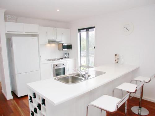 a white kitchen with a sink and a counter at Do Drop Inn - Port Willunga - C21 SouthCoast Holidays in Port Willunga