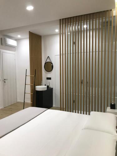 a bedroom with a white bed and a sliding glass door at Le Dimore Degli Archi Catania in Catania