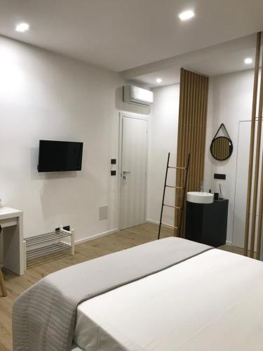 a bedroom with a bed and a tv on the wall at Le Dimore Degli Archi Catania in Catania