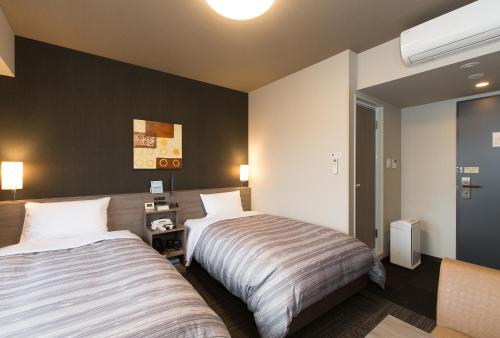 Säng eller sängar i ett rum på Hotel Route-Inn Koka Minakuchi -Kokudo 1 gou-