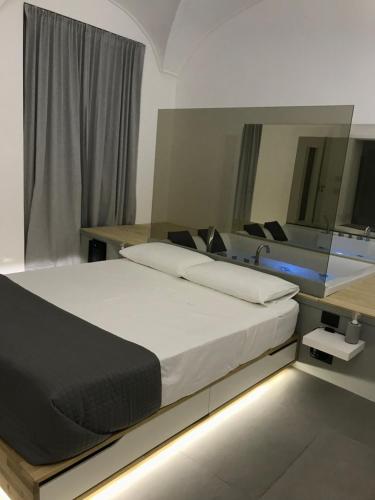 a bedroom with a large bed and a mirror at Le Dimore Degli Archi Catania in Catania