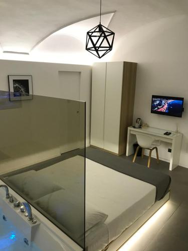a room with a bed and a desk and a lamp at Le Dimore Degli Archi Catania in Catania