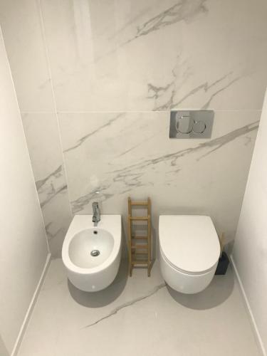 a white bathroom with a toilet and a sink at Le Dimore Degli Archi Catania in Catania
