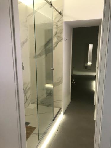 a glass shower door with a hallway in a room at Le Dimore Degli Archi Catania in Catania
