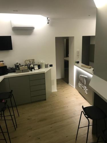 a kitchen with a counter and chairs in a room at Le Dimore Degli Archi Catania in Catania