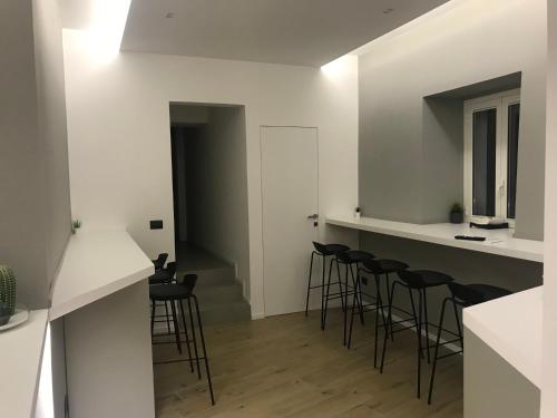 a bar with stools in a room with white walls at Le Dimore Degli Archi Catania in Catania