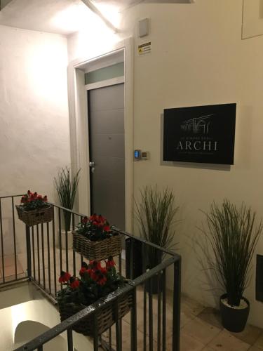 a staircase with two baskets of flowers and a door at Le Dimore Degli Archi Catania in Catania