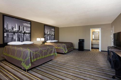 SidneyにあるTravel Inn Of Sidney Ohioのベッド2台と薄型テレビ付きのホテルの部屋