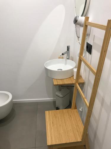 a bathroom with a white sink and a wooden ladder at Le Dimore Degli Archi Catania in Catania