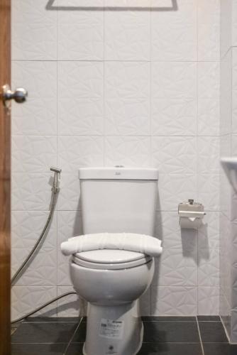 a bathroom with a toilet with two towels on it at Phuket Airport Place in Nai Yang Beach