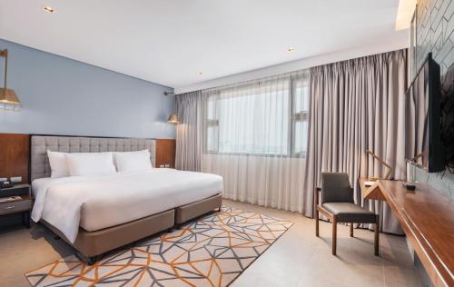 a bedroom with a bed and a desk and a tv at Summit Galleria Cebu in Cebu City