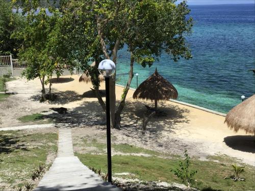 a street light next to a beach with the ocean at Cuestas Beach Resort and Restaurant in Badian