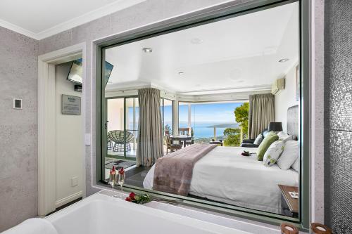 a bedroom with a large window with a view of the ocean at Arthurs Views in Arthurs Seat