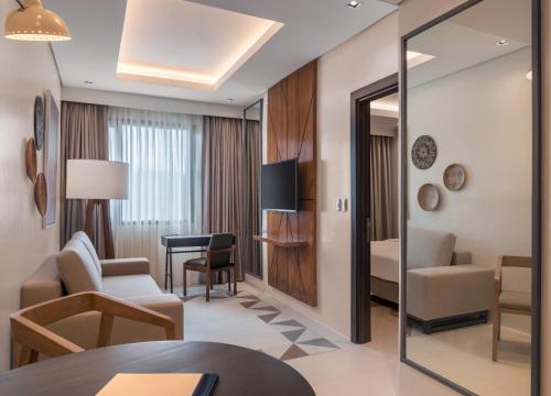 a hotel suite with a living room and a bedroom at Summit Galleria Cebu in Cebu City