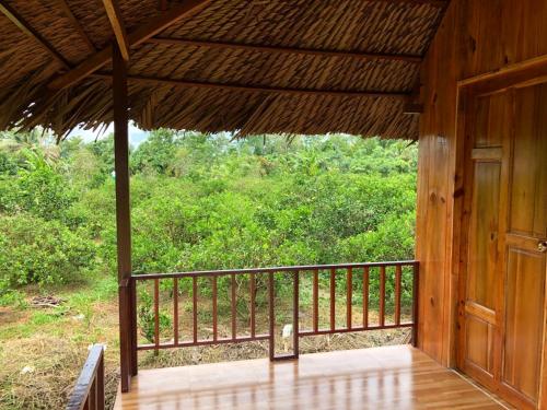 a porch of a wooden house with a wooden door at MEKONG DANIEL HOMESTAY CAN THO in Can Tho
